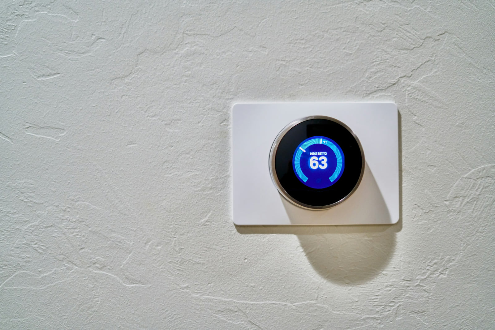A wall-mounted smart thermostat displaying a cooling temperature.