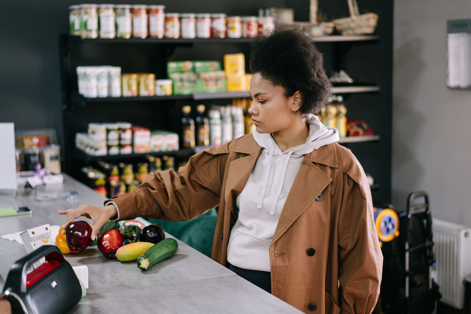A grocery-store worker handling fresh vegetables at a counter.