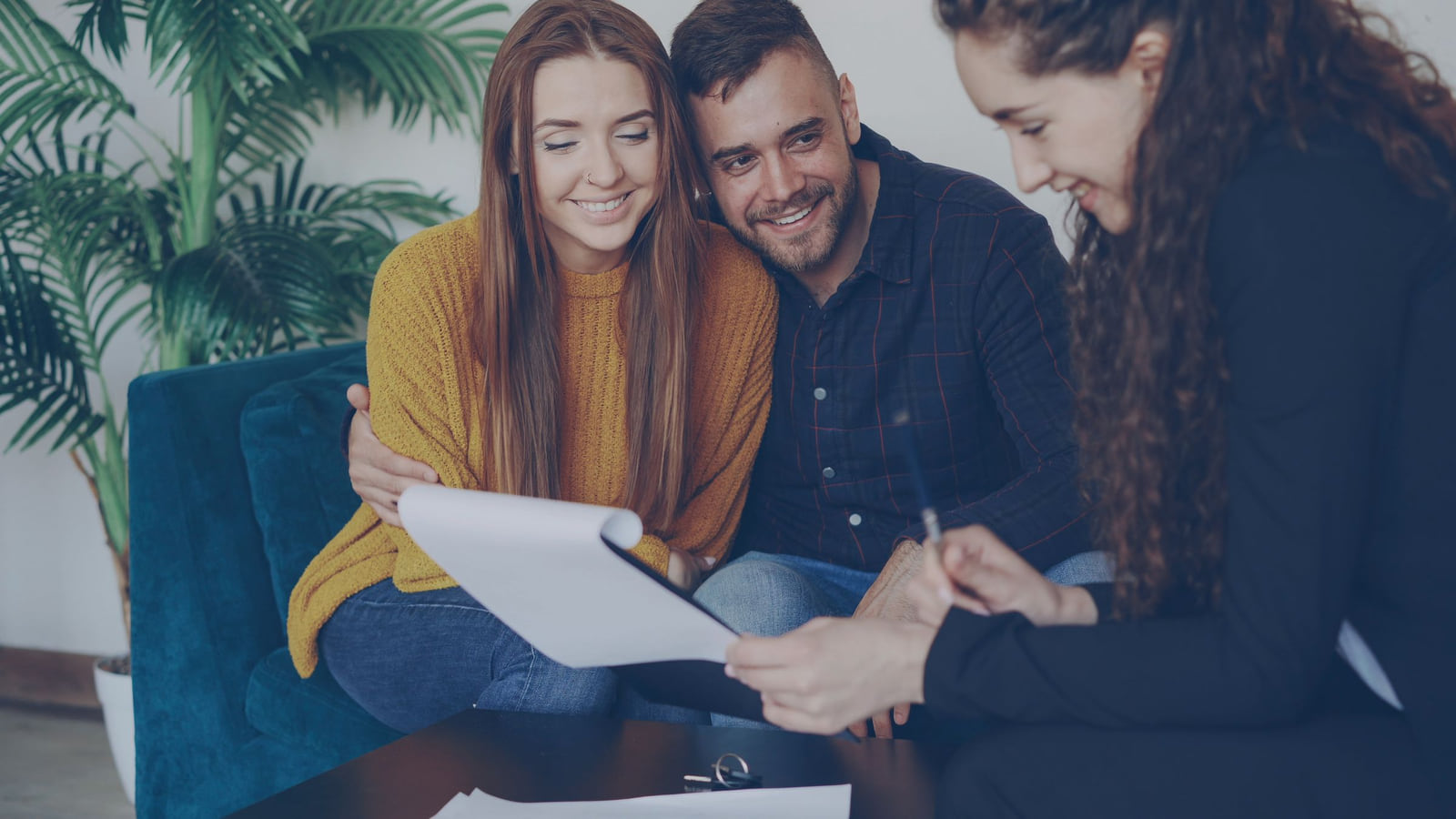 A couple discussing documents with an adviser.