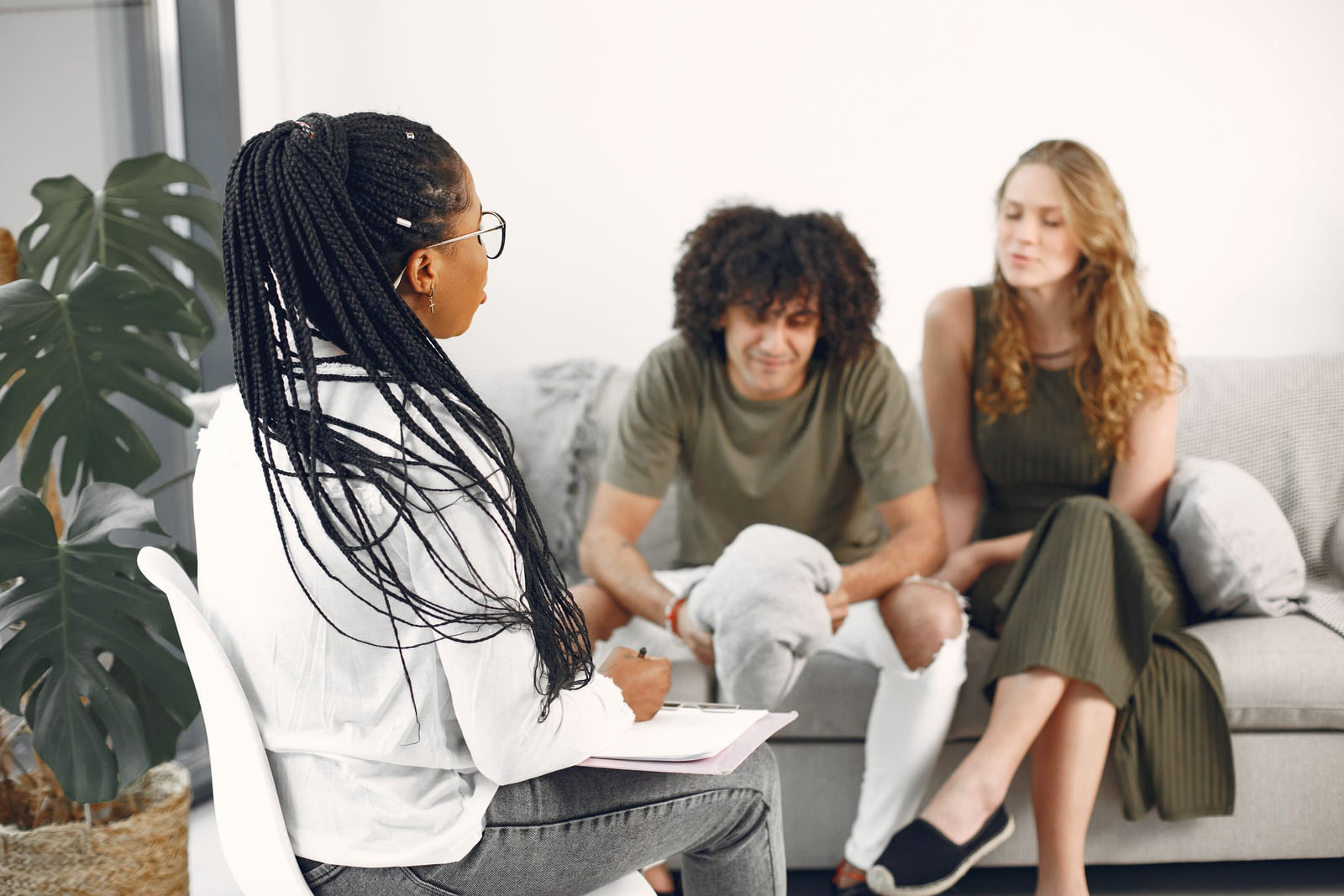 A therapist meeting with a couple seated together on a sofa.