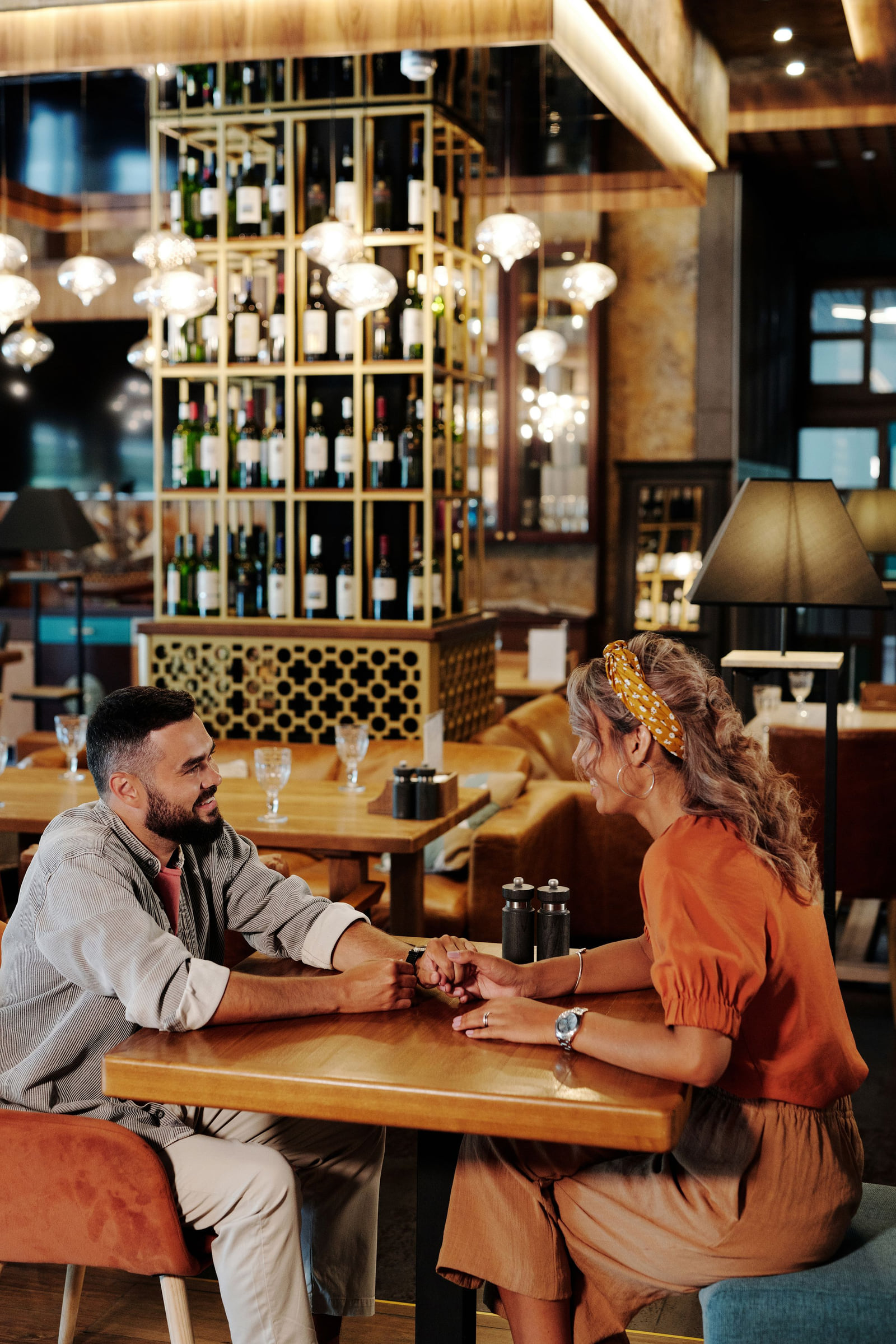 Two diners talking across a table inside a restaurant.