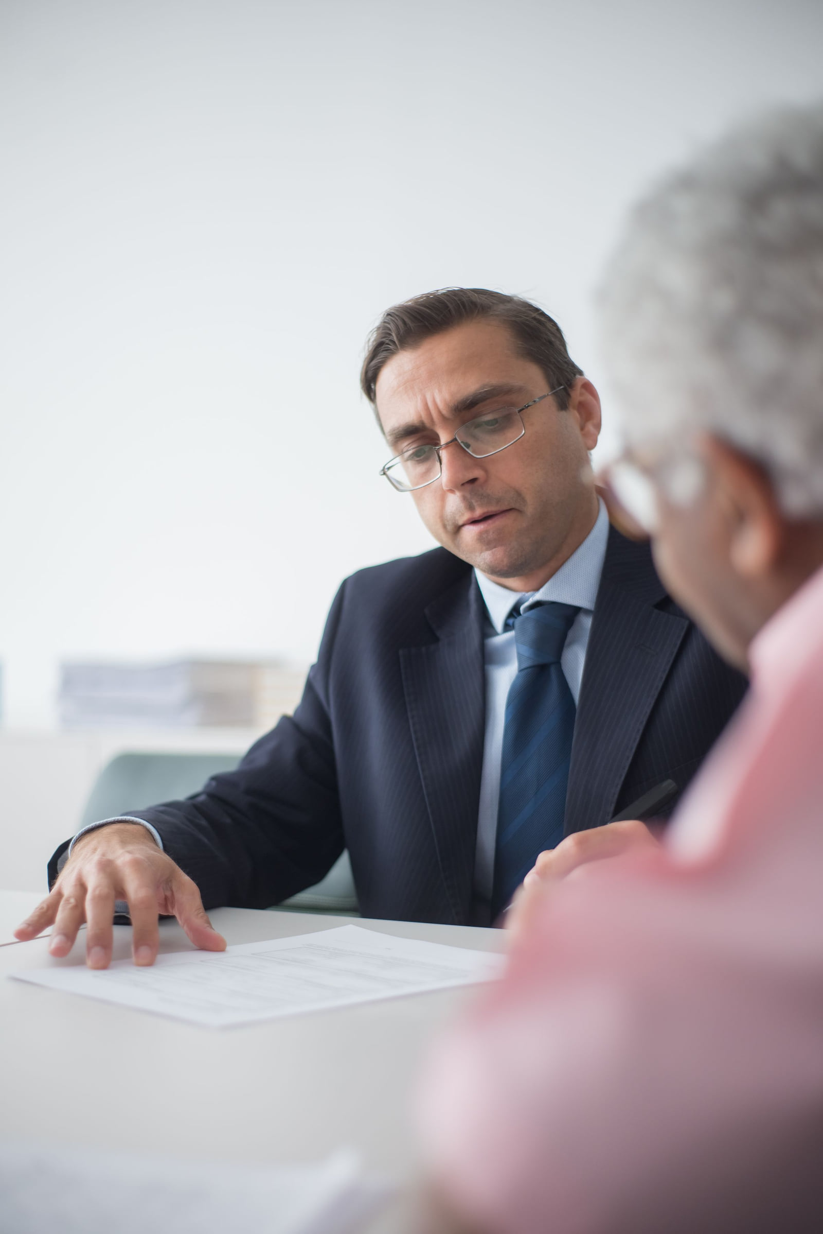 An adviser reviewing paperwork with a seated client.