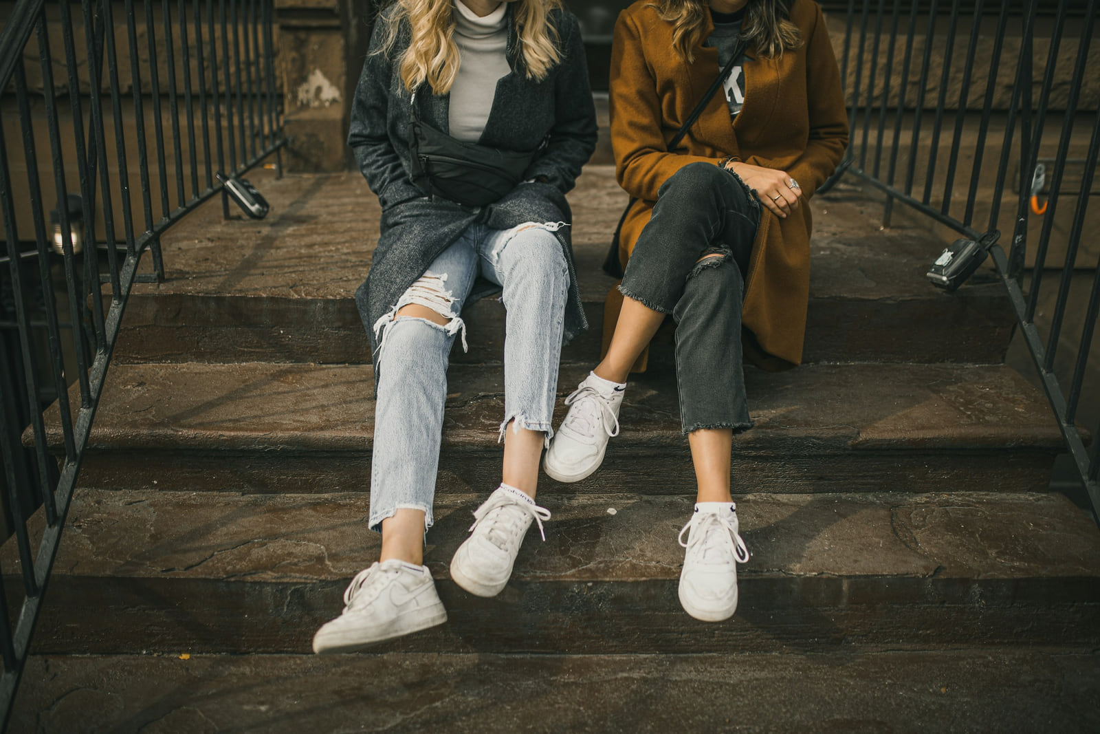 Two people sitting on the front steps of a Brooklyn building.