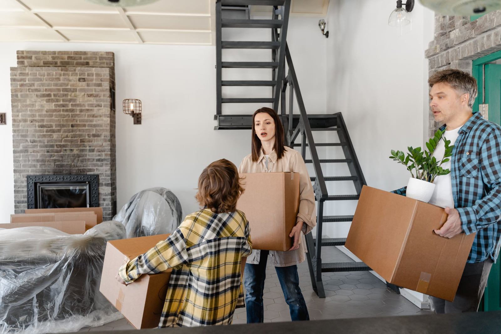 Family members unpacking moving boxes inside a new home.
