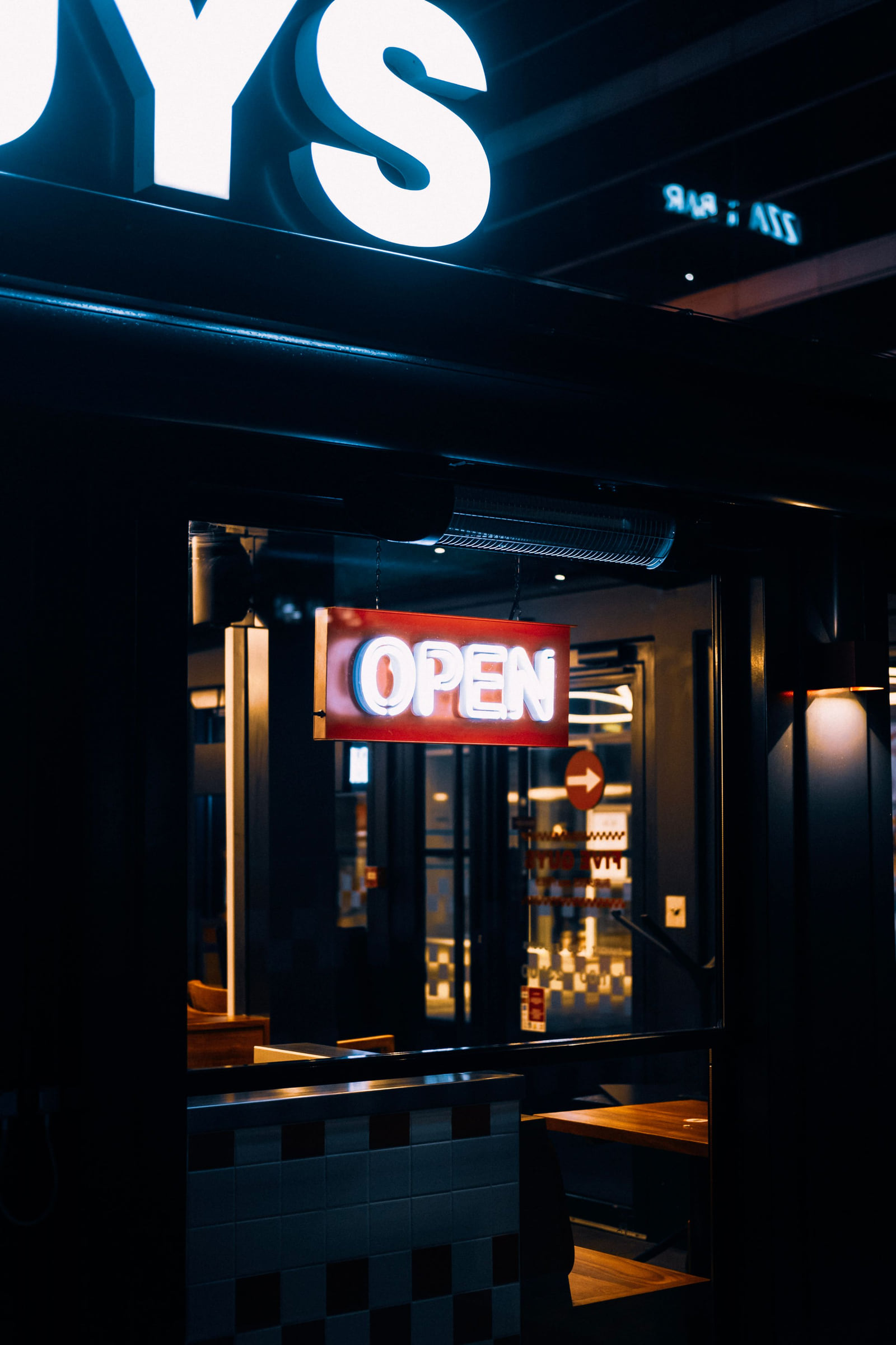 An illuminated Open sign in a shop entrance at night.