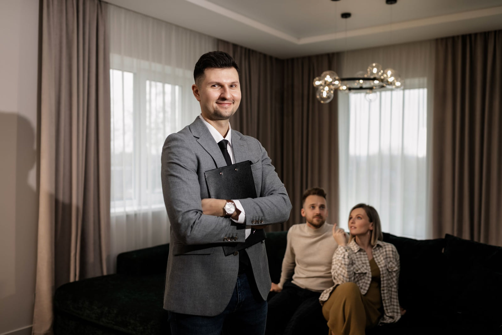 A property professional holding a folder while clients sit nearby.