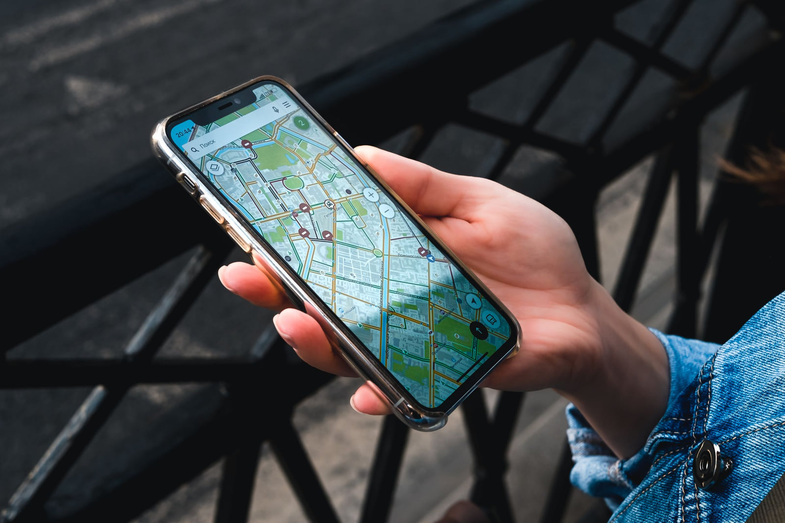 A person holding a smartphone with a street map displayed.