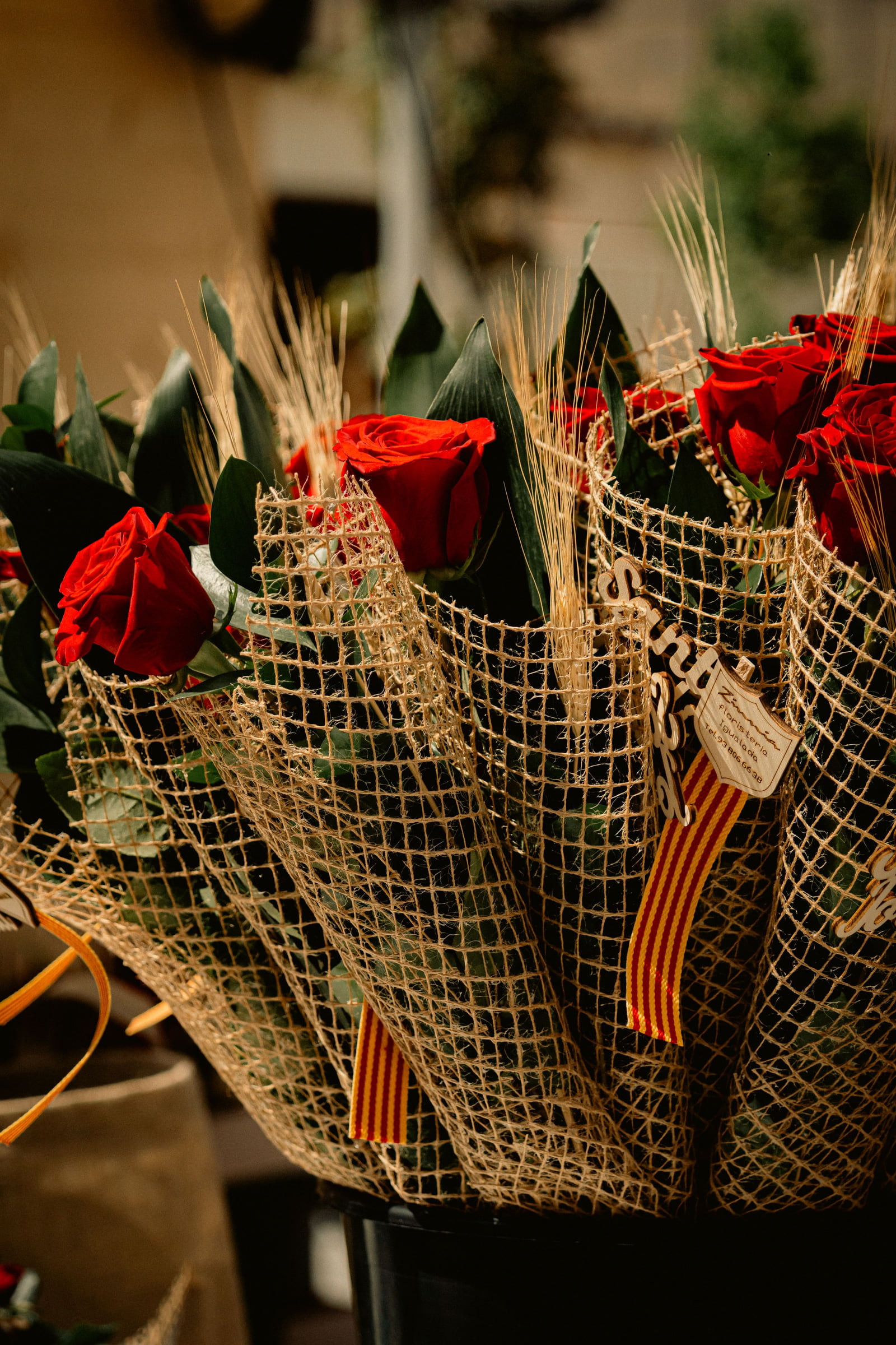 Red roses wrapped in burlap and tied as a bouquet.
