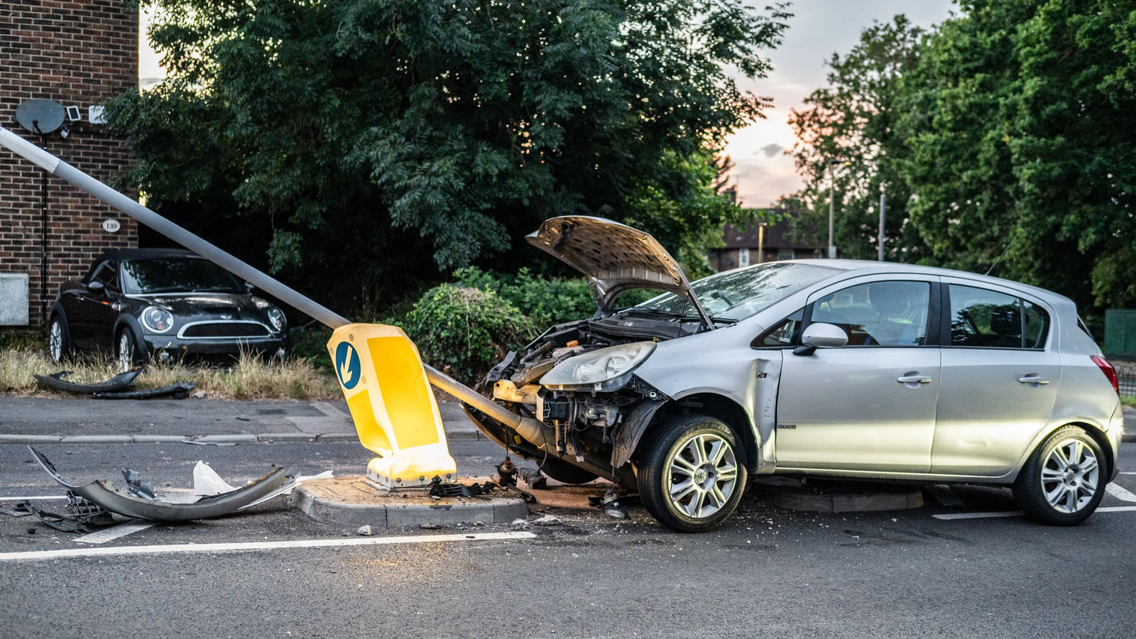 Two damaged cars on a city street after a collision.