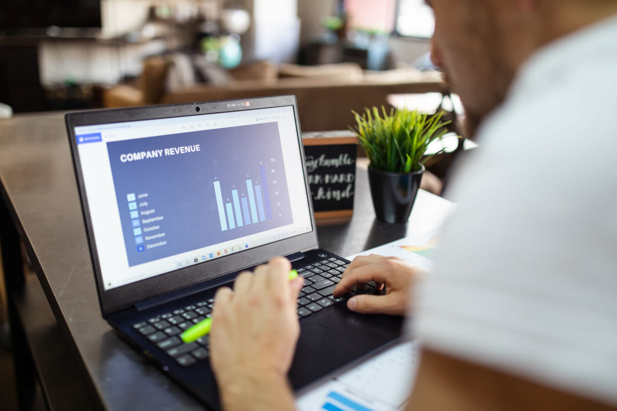 A person working on a laptop displaying a bar chart.
