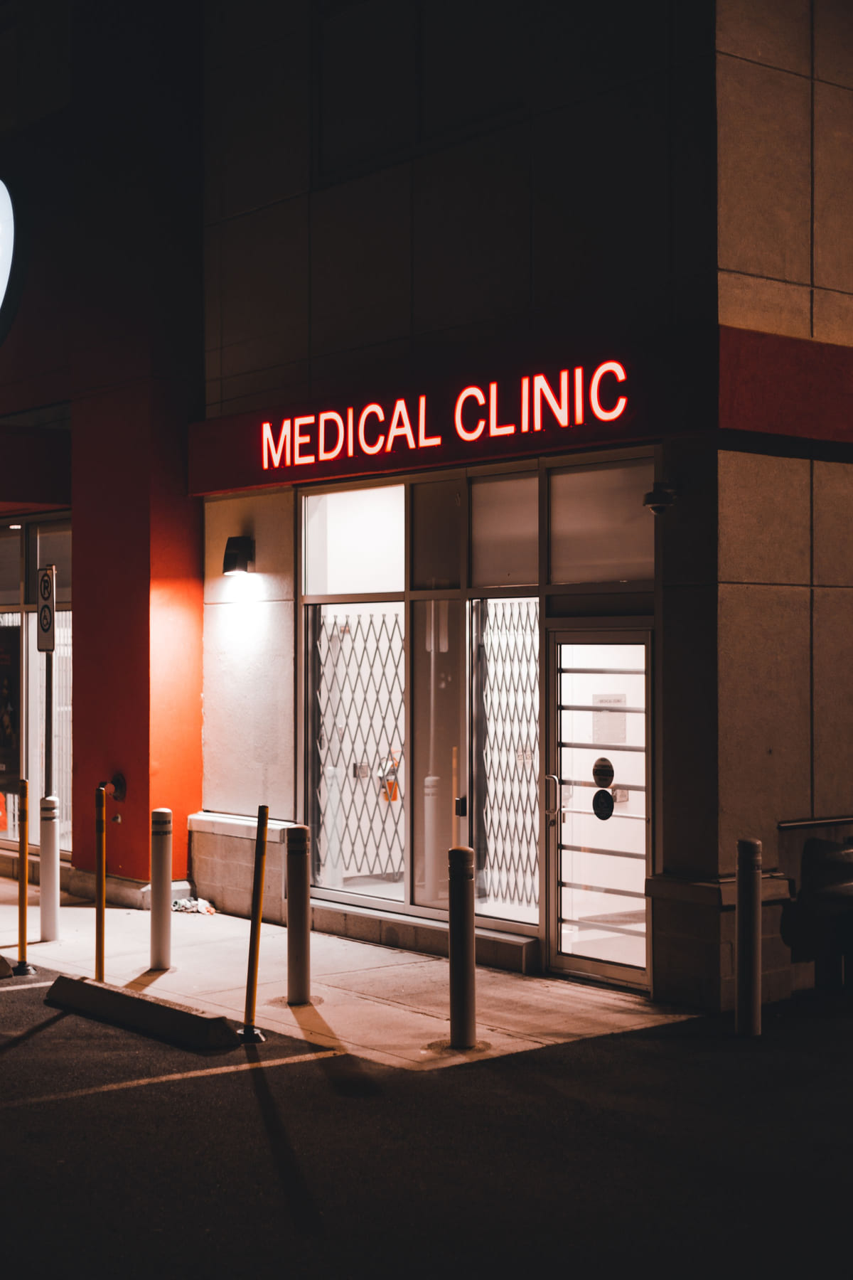 A medical clinic entrance illuminated beneath a Medical Clinic sign at night.
