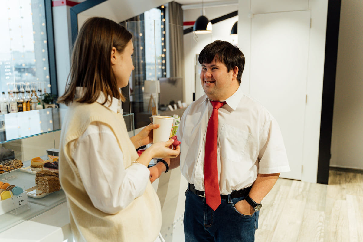A café manager listening to a customer.