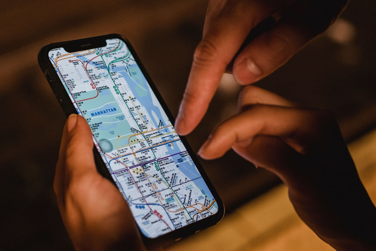 Hands checking a city map on a smartphone.