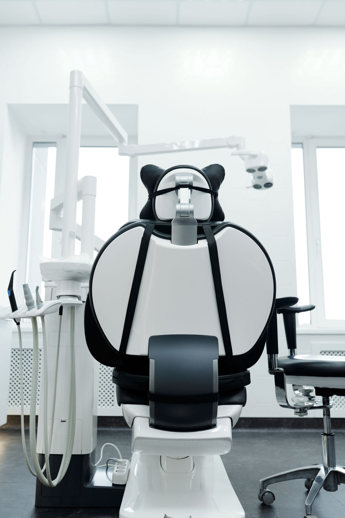 A dental chair and treatment equipment in a bright dental room.