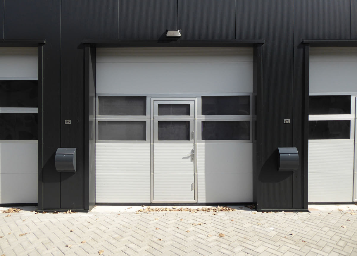 A modern garage entrance with a door and adjoining pedestrian entrance.