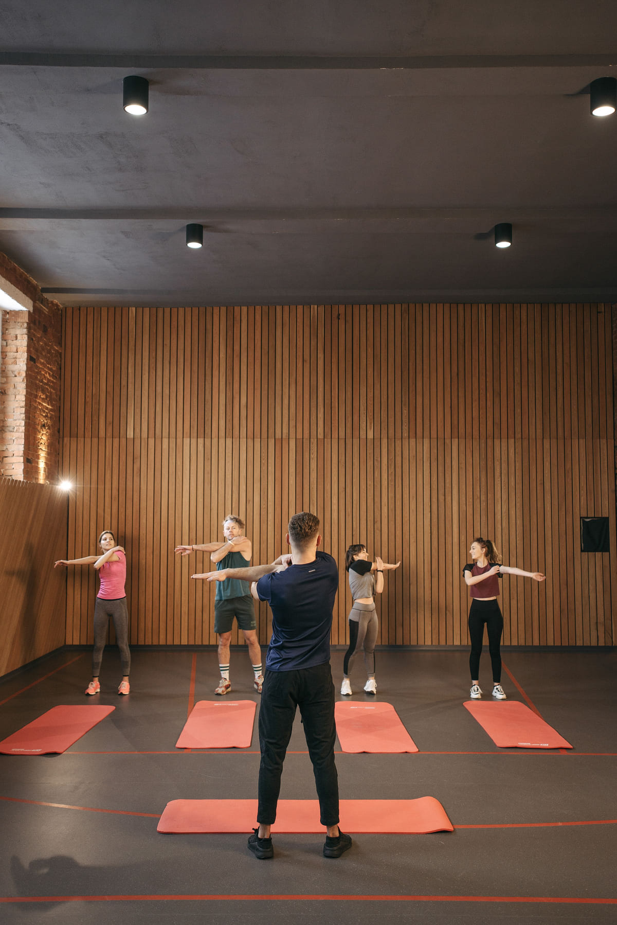 A small group exercising on mats in a fitness studio.