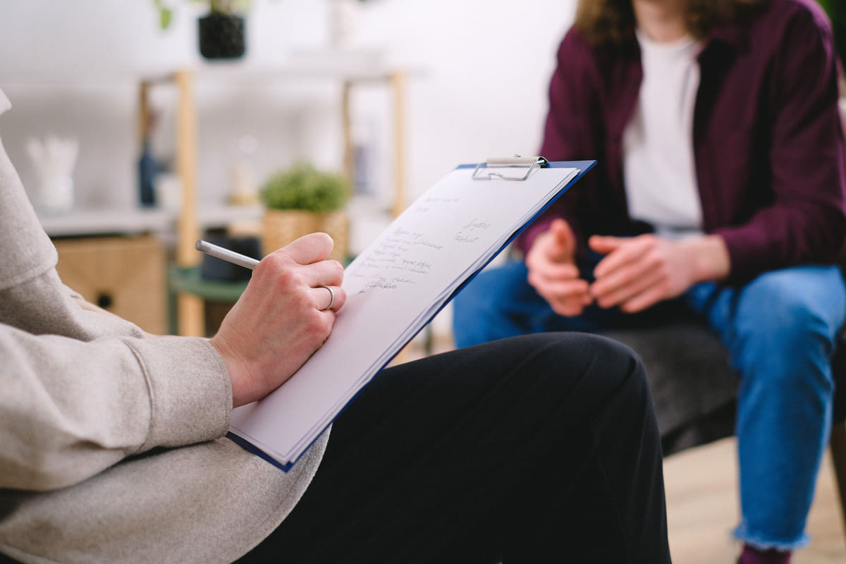 A therapist taking notes during a consultation.