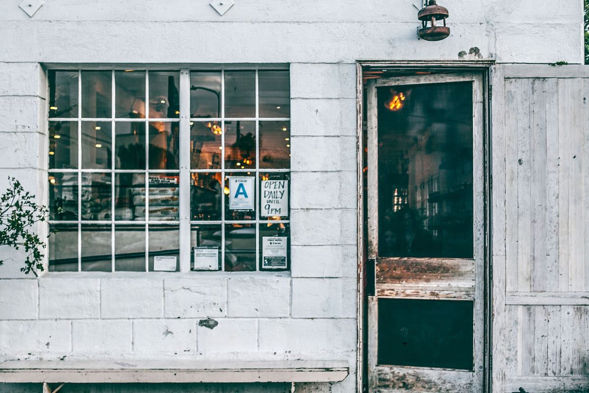 A small café's entrance and window seen from the street.
