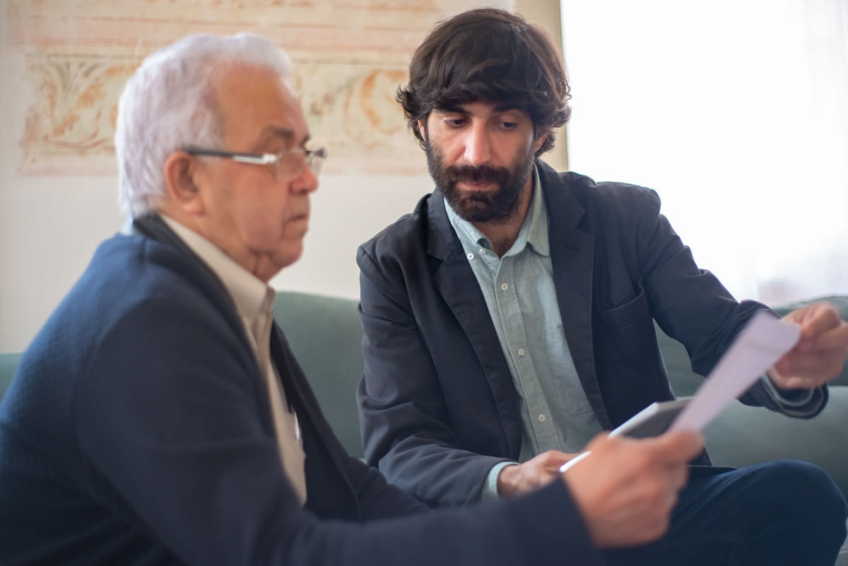 An adviser explaining printed documents to an older client.