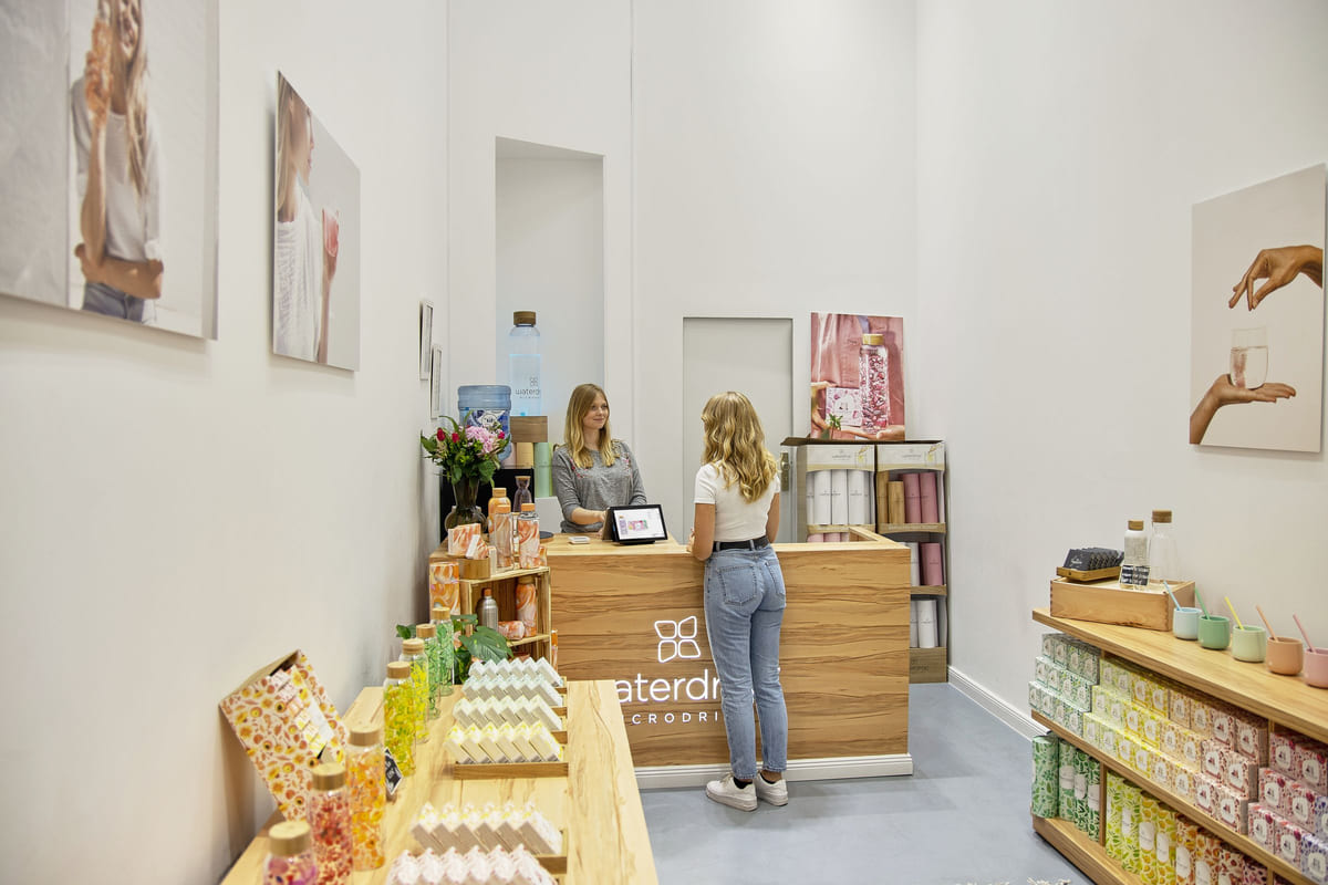 A customer speaking with a shopkeeper at a boutique counter.