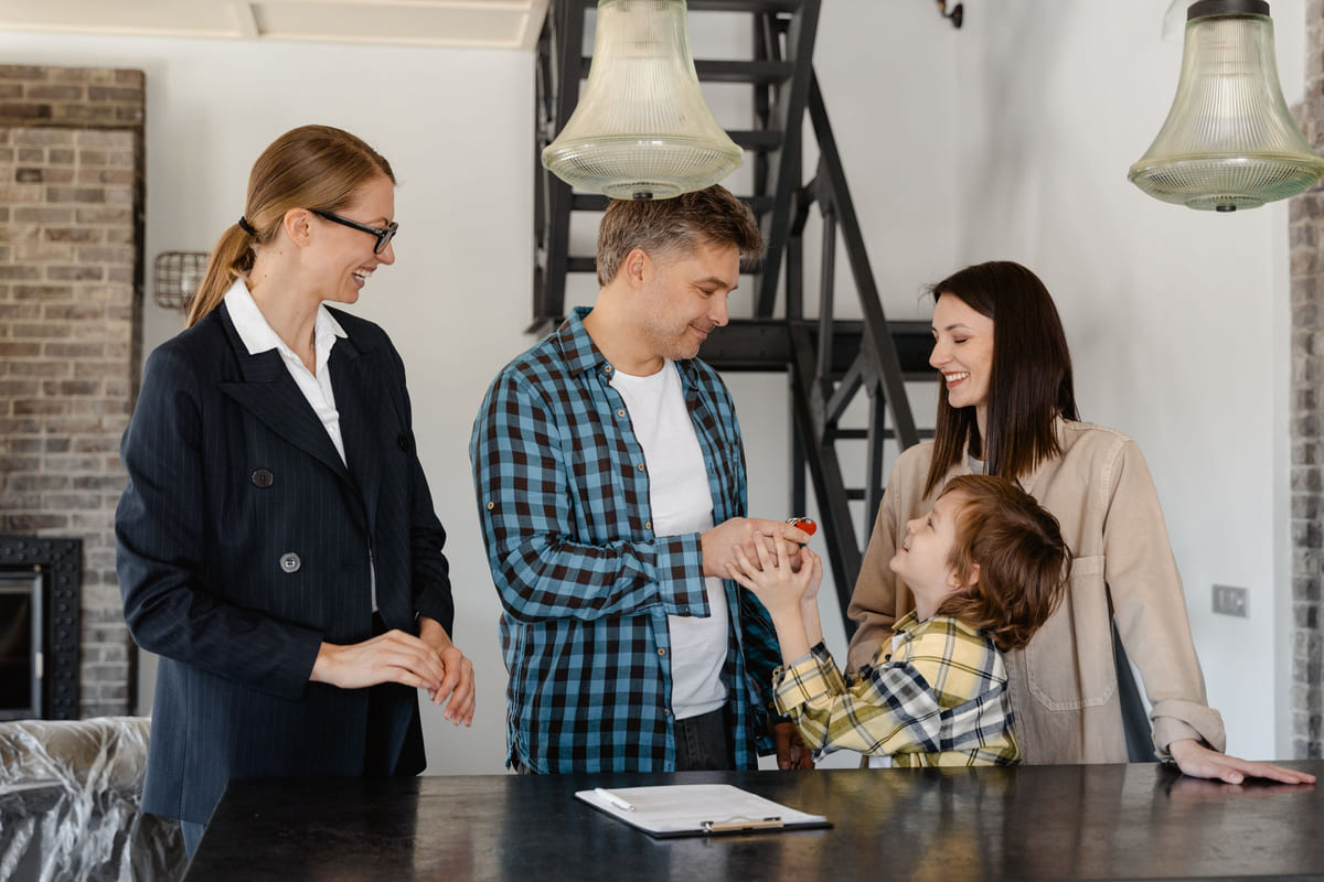 A property agent meeting with a family inside a house.