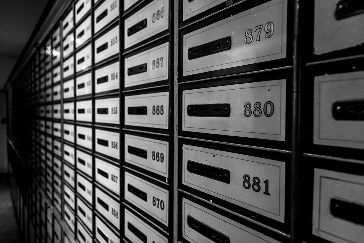 Rows of numbered metal mailboxes in a shared building.