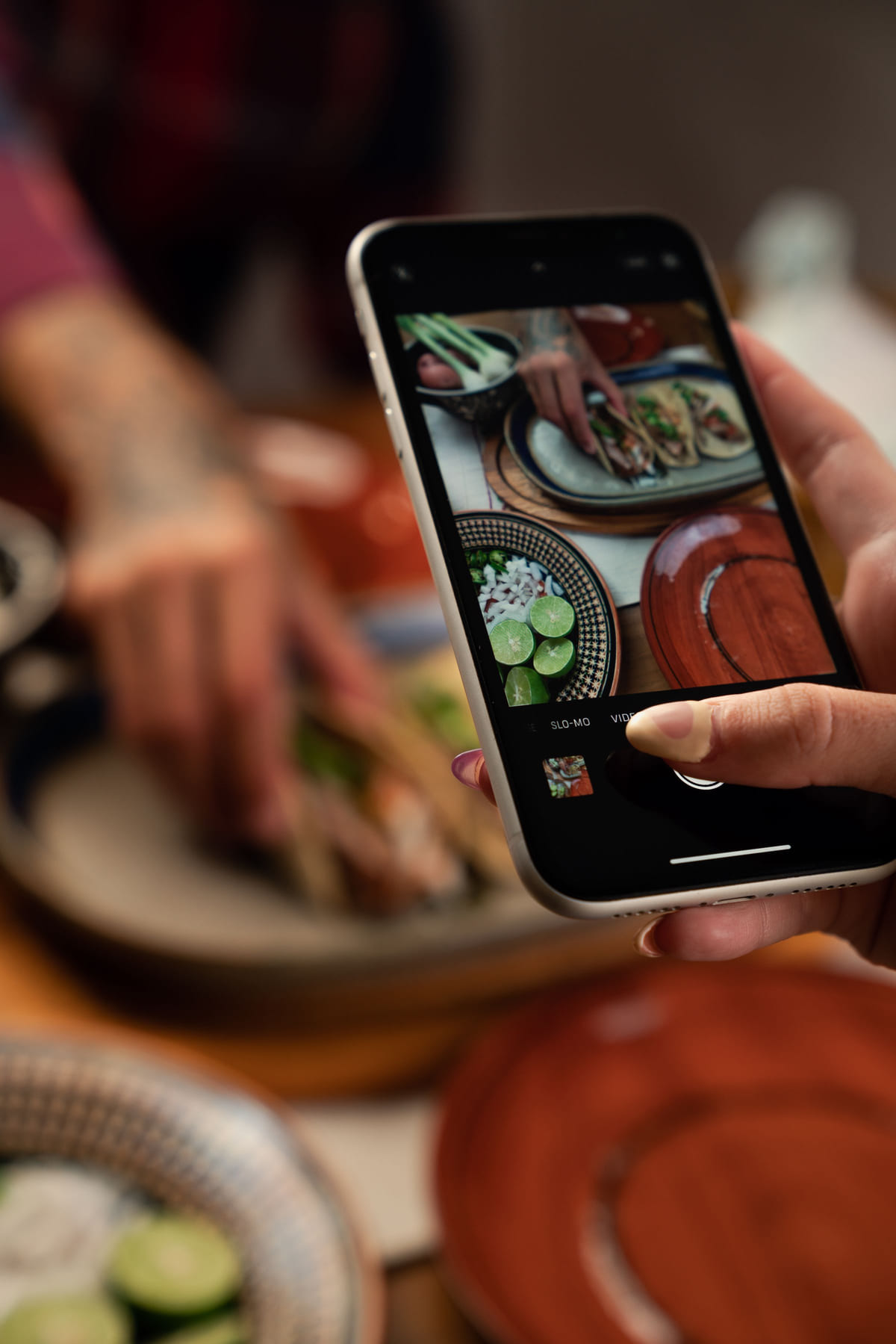 A smartphone being used to photograph a plated meal.