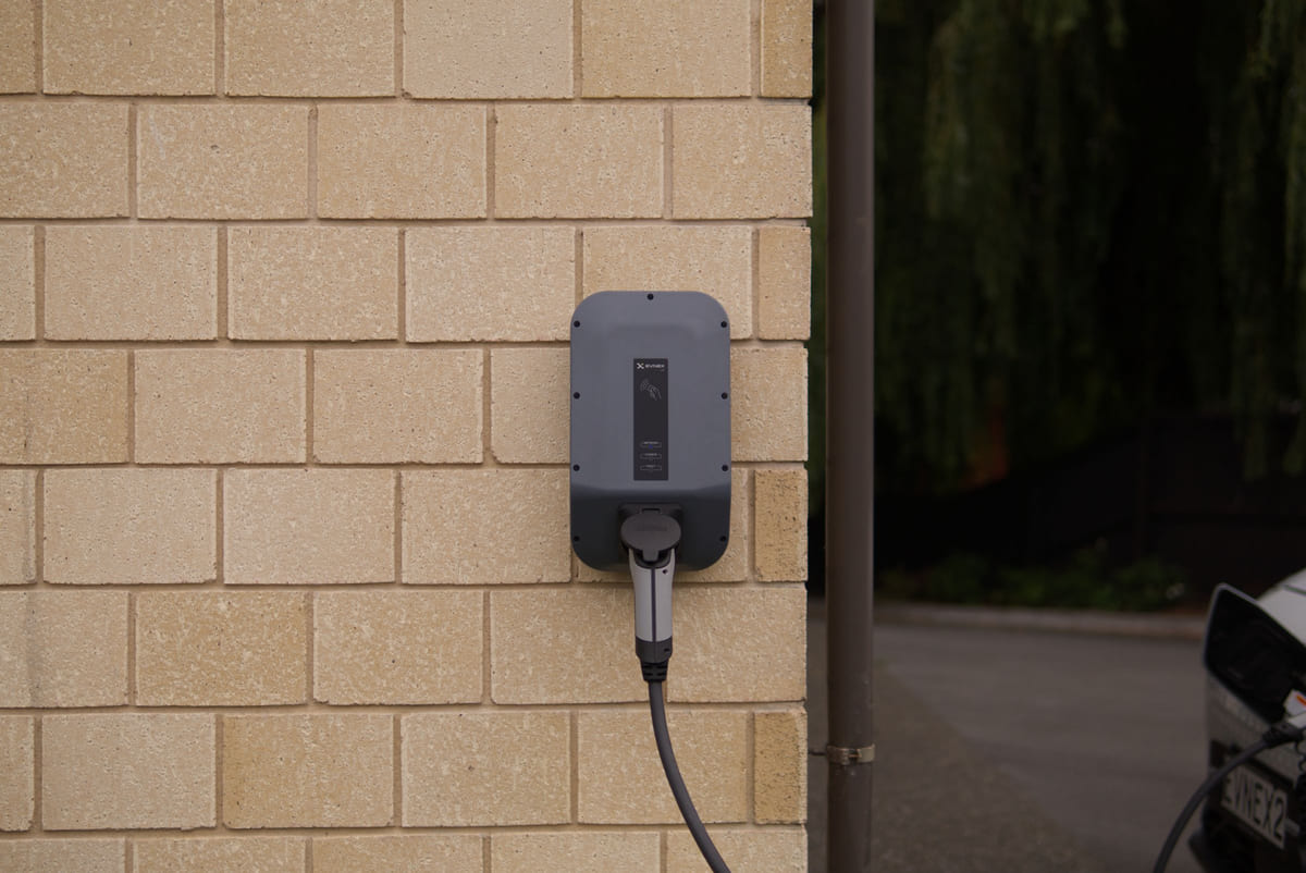An electric-vehicle charging unit mounted on a garage wall.