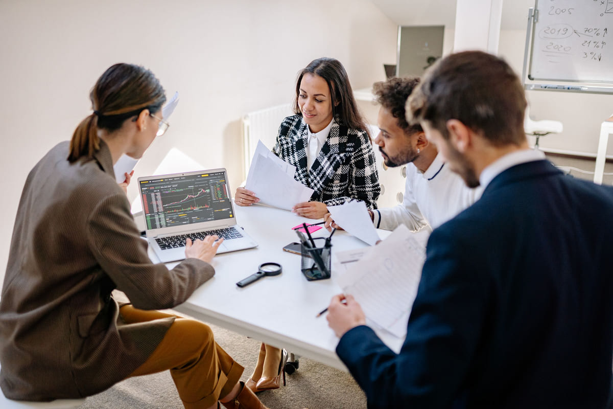 Colleagues reviewing information on a laptop during a meeting.
