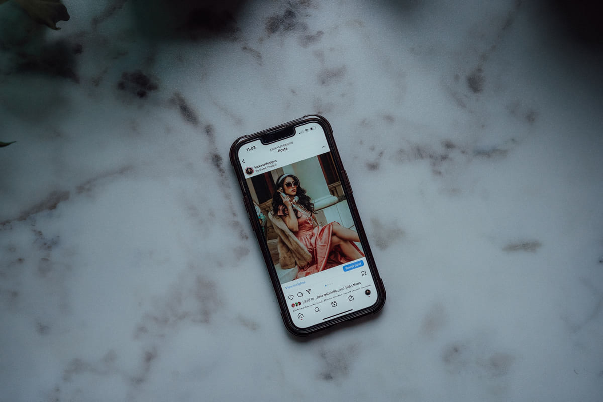 A smartphone displaying a social-media post on a marble surface.
