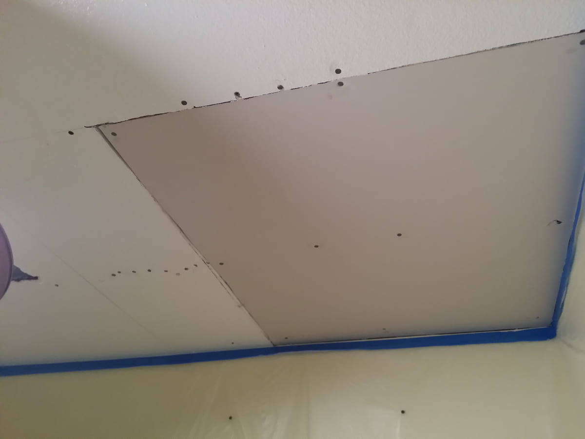 Ceiling drywall being repaired after water damage.