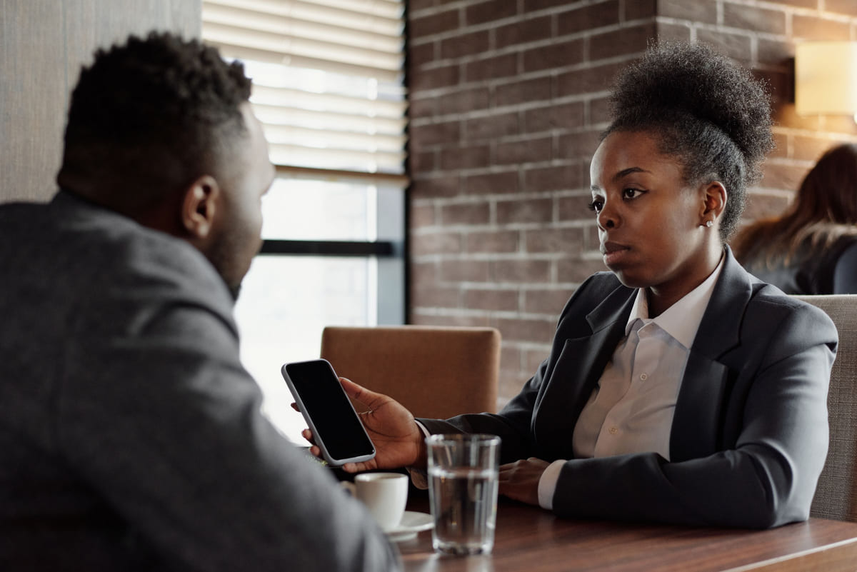 Two professionals talking across a café table.