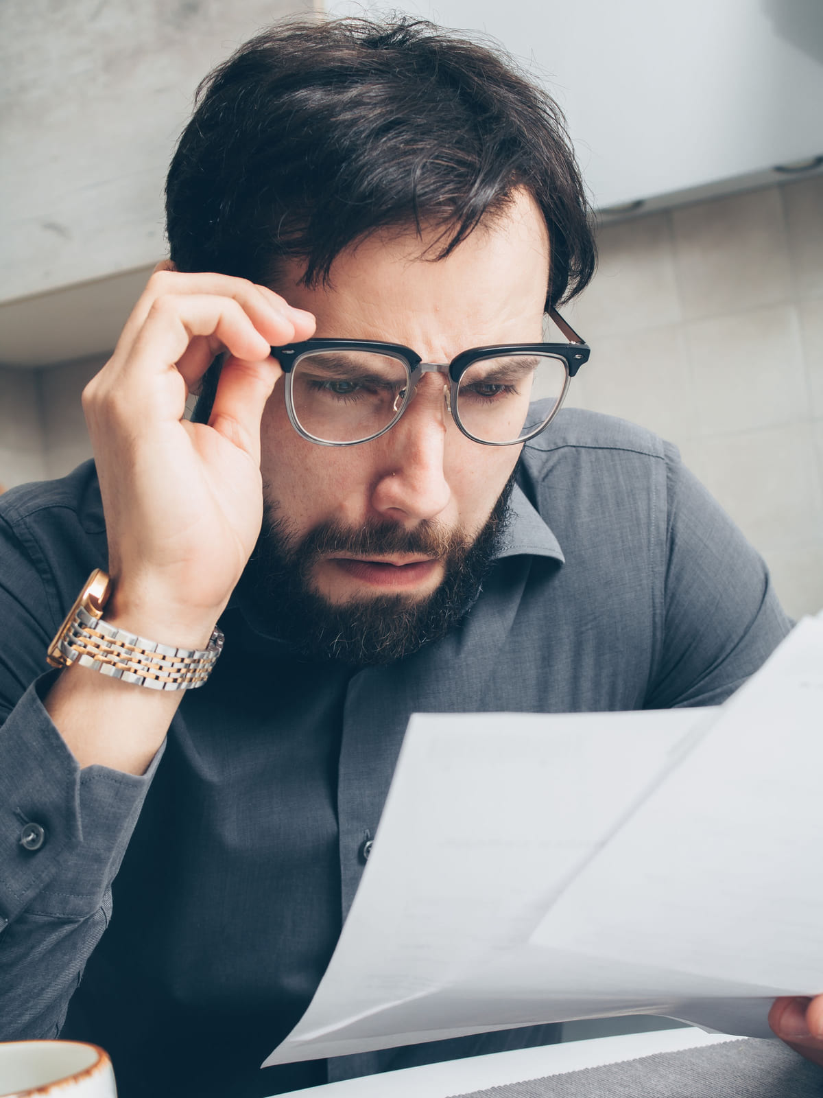 A person reviewing bills and other paperwork at a desk.