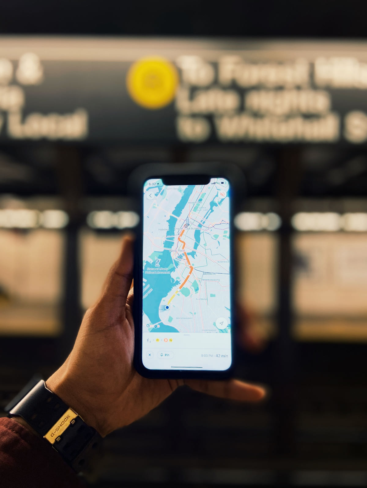 A hand holding a smartphone with a map displayed outside a shop.